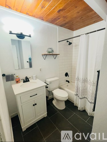 A bathroom with a toilet, sink, and shower.