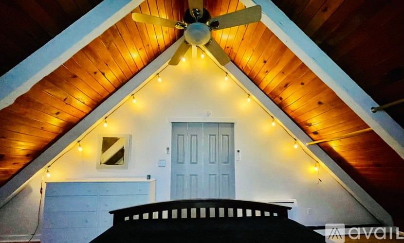 A house with a white door and a ceiling fan with lights.
