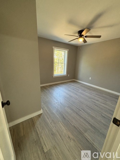 A room with a ceiling fan and a window.