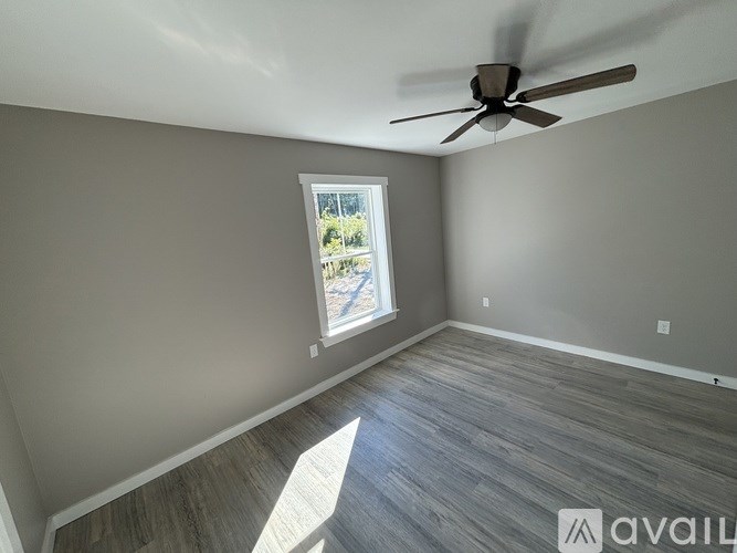 A room with a ceiling fan and a window letting in natural light.