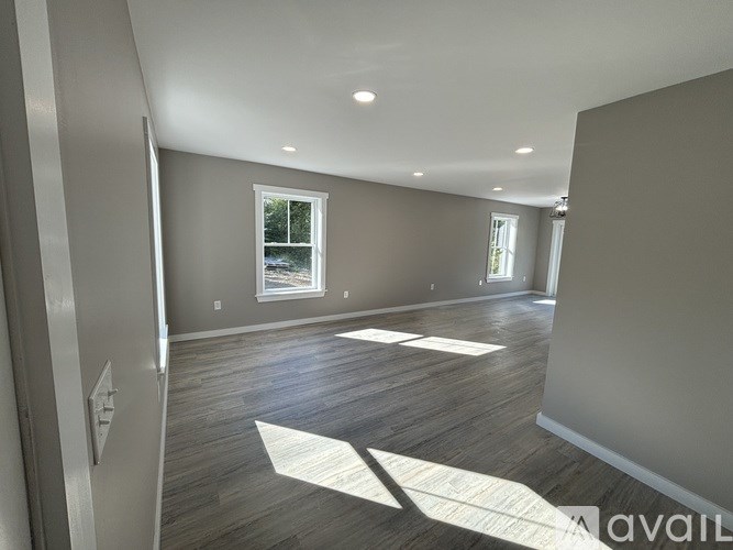 A room with wooden flooring and a window letting in natural light.
