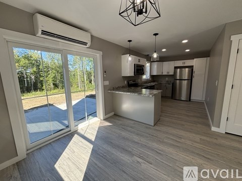 A modern kitchen with a large island and stainless steel appliances.