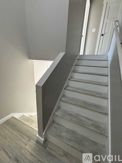 A staircase with a grey railing and wooden steps.