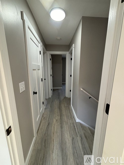 A long hallway with white doors and a light on the ceiling.