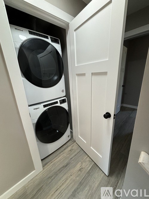 A white door is open to a laundry room with a washer and dryer.