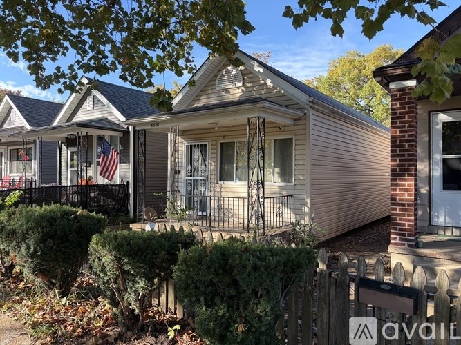 A house with a flag on the porch is for sale.