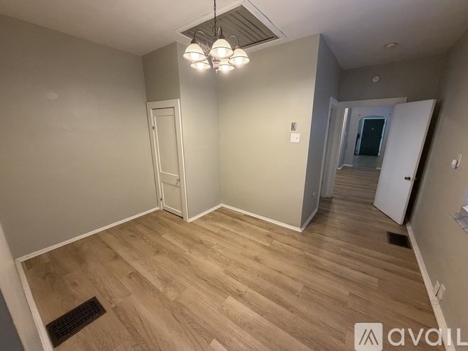 A room with wooden flooring and a white door.