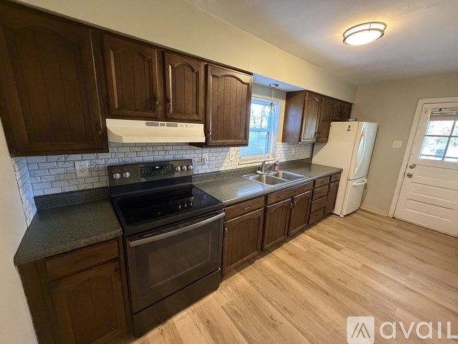 A kitchen with dark wood cabinets and a white refrigerator.