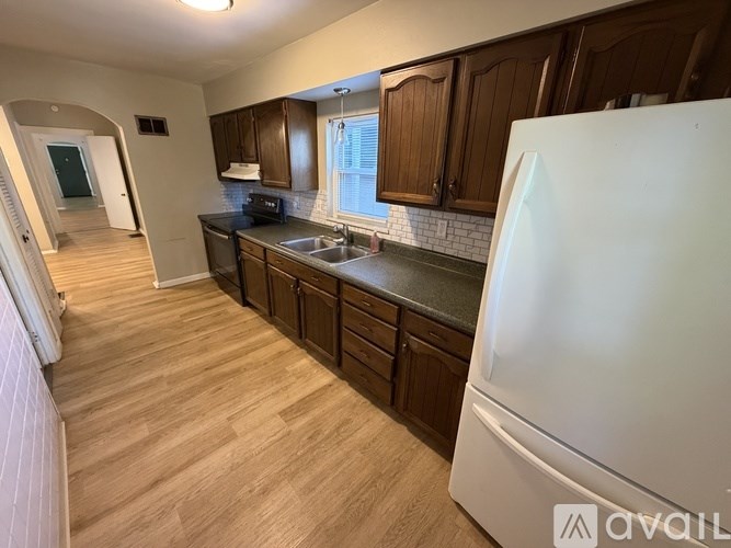A kitchen with wooden cabinets and a white refrigerator.