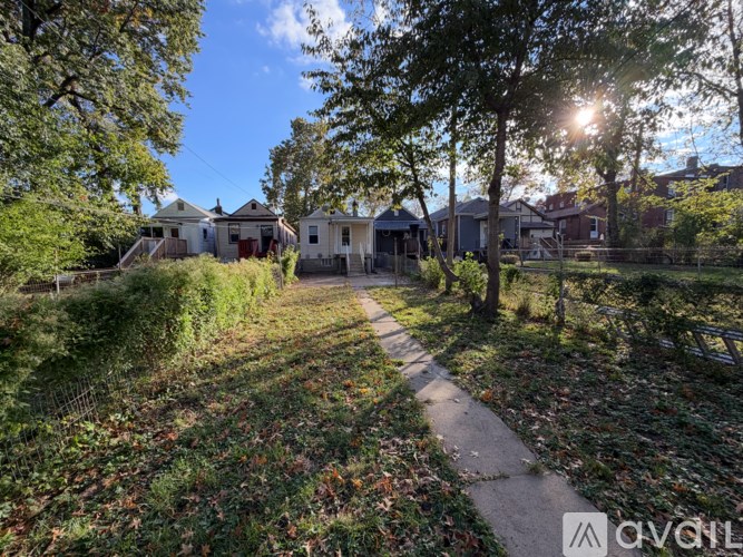 A sunny day in a residential area with houses and trees.