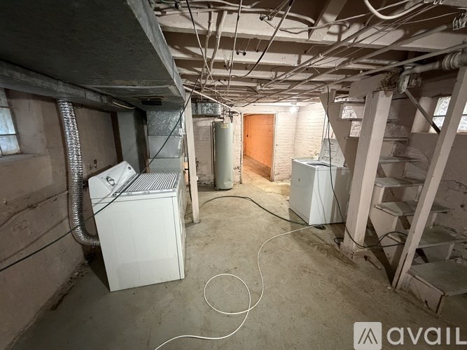A room with a white air conditioner and a white refrigerator.