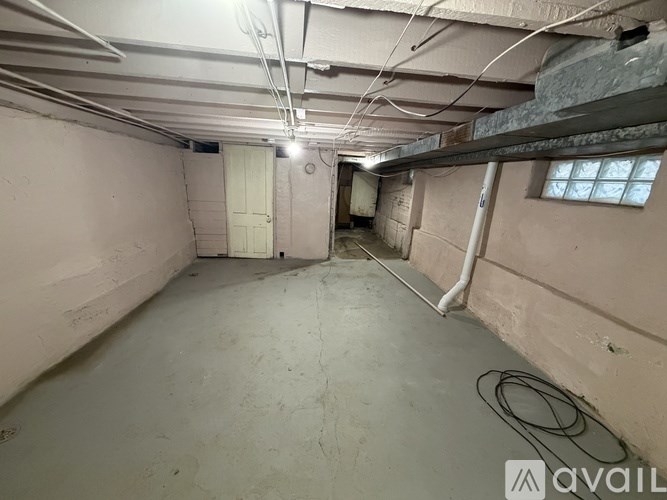 A spacious, unfinished basement with a door and a window.