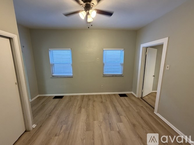 A room with wooden flooring and a ceiling fan.