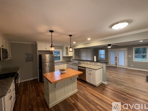 A modern kitchen with wooden floors and a central island.
