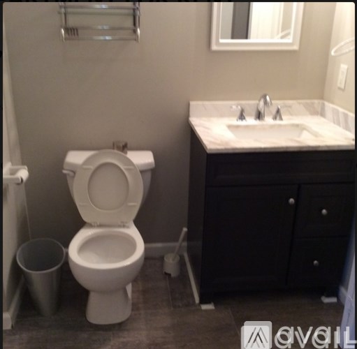 A white toilet sits next to a sink in a bathroom.
