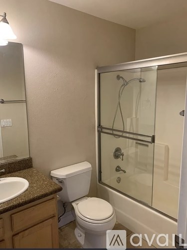 A bathroom with a toilet, sink, and shower.