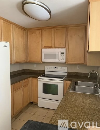 A kitchen with wooden cabinets and a white fridge.