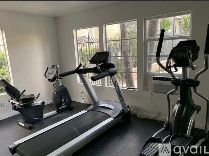 A home gym with a treadmill, elliptical trainer, and stationary bike.
