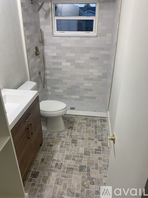 A bathroom with a toilet, sink, and tiled floor.