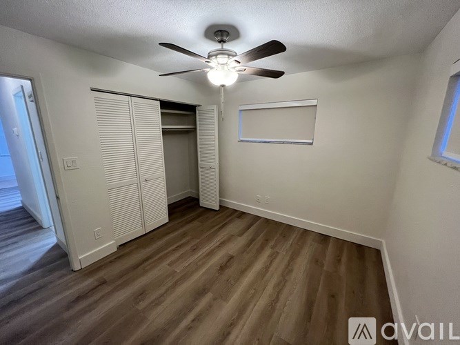 A room with a ceiling fan and a whiteboard on the wall.