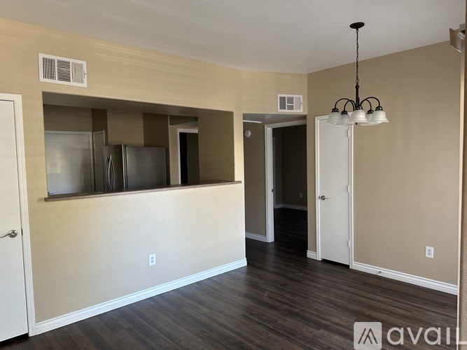 A kitchen area with a refrigerator, cabinets, and a stove top oven.