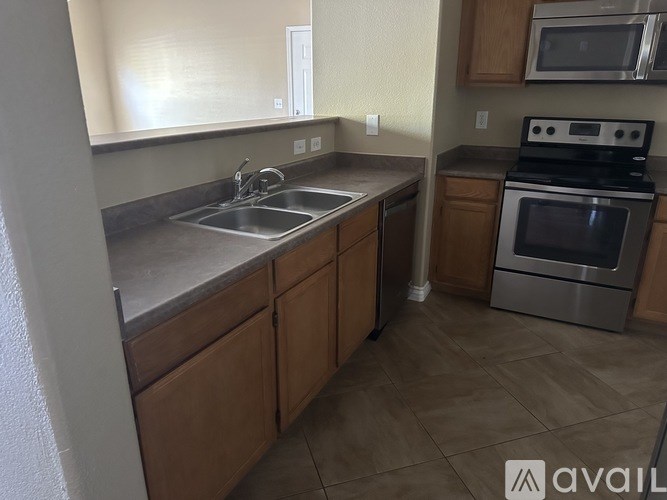 A kitchen with a stove, sink, and cabinets.