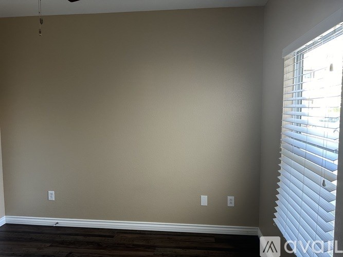 A room with beige walls and wooden flooring.