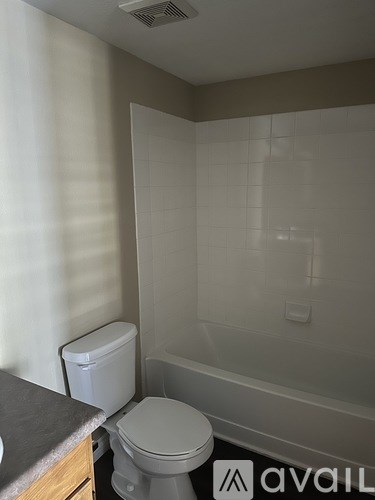 A white toilet sits in a bathroom with a glass shower door.