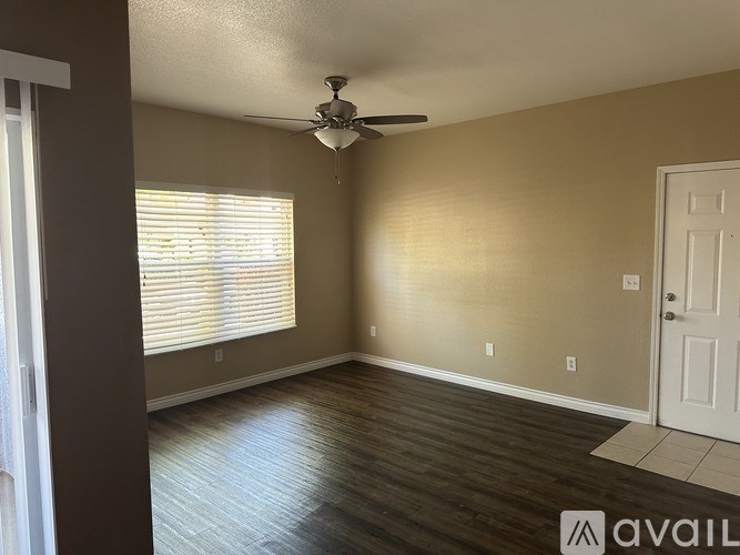 A room with a ceiling fan and a door.