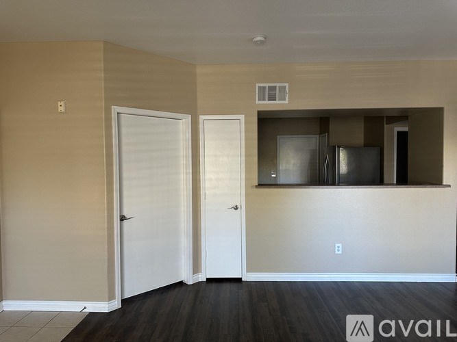 A kitchen area with a refrigerator, oven, and cabinets.
