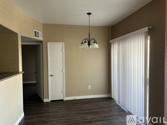 A room with a chandelier hanging from the ceiling and a white door.