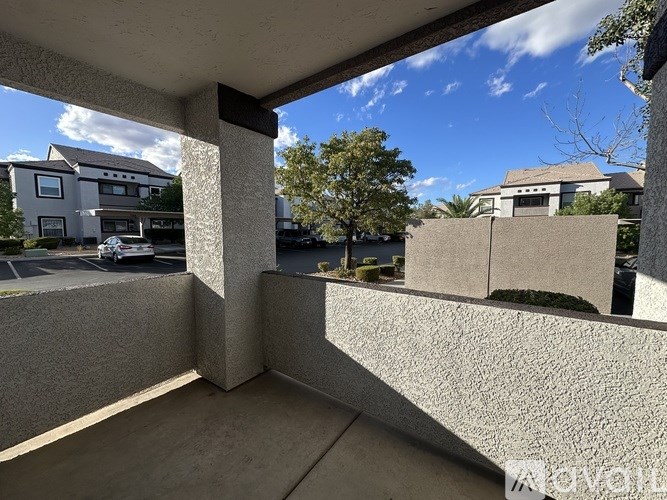 A view from a balcony looking out at a parking lot and houses.