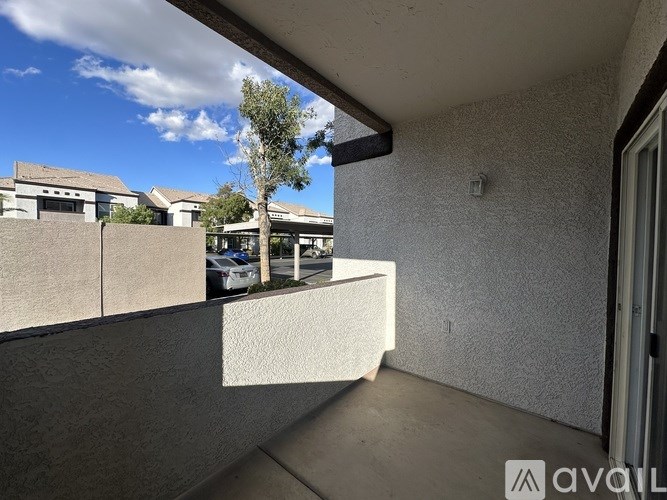 A balcony with a concrete floor and a wall with a rough texture.