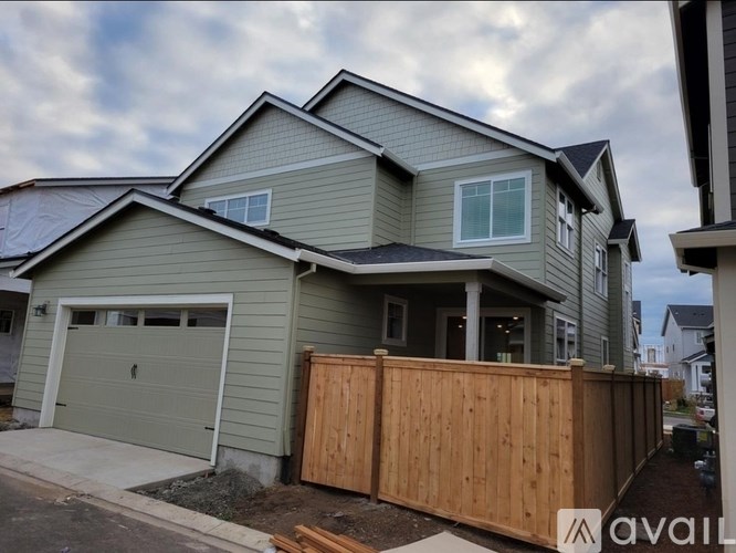 A house with a garage and a wooden fence in front.
