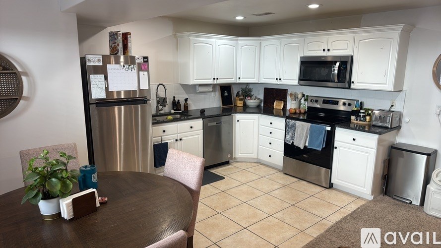 A kitchen with white cabinets and a wooden table.