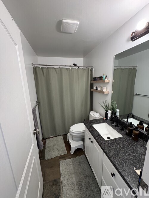 A bathroom with a toilet, sink, and shower.