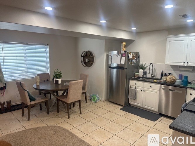 A kitchen with a table and chairs in the middle of the room.