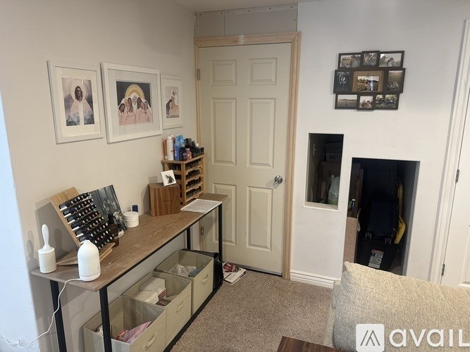 A room with a white door and a shelf with various items on it.