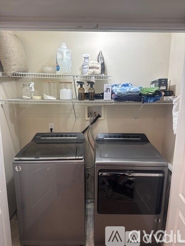 A laundry room with two front loading washing machines.