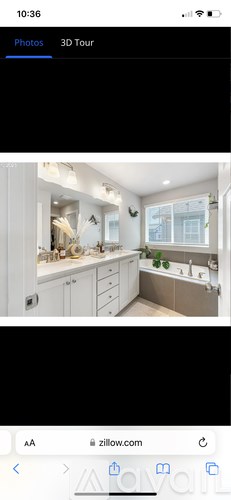 A white kitchen with a sink and a window.