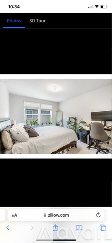 A bedroom with a bed, a chair, and a window.