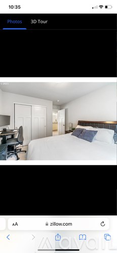 A bedroom with a bed, desk, and chair.