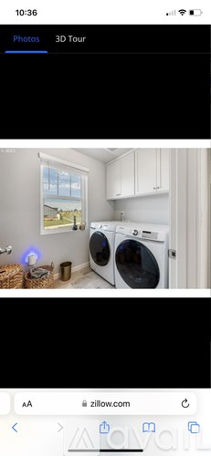 A 3D tour of a room with a washing machine and a window.