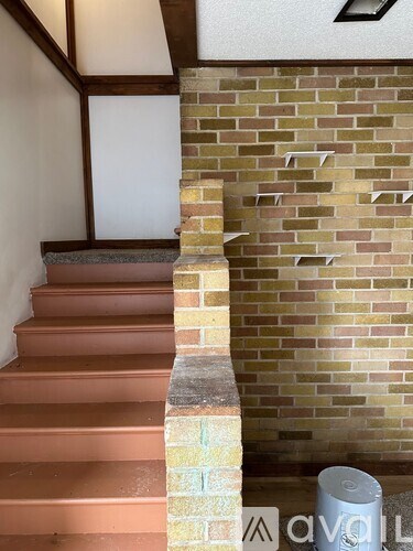 A set of stairs with a brick wall on one side.