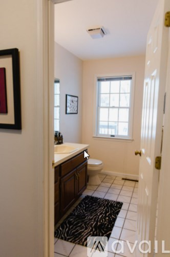 A bathroom with a toilet, sink and window.