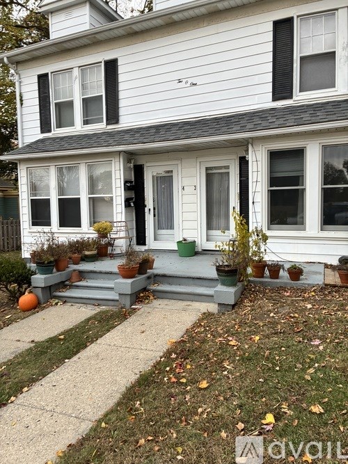 A white house with a grey front porch and steps.