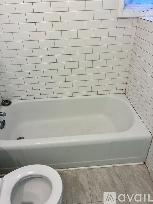A white bathroom with a white tub and toilet.
