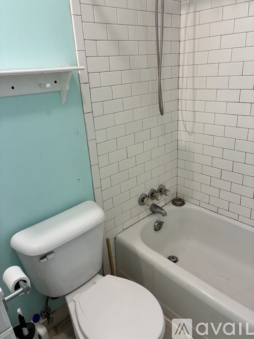 A white toilet sits next to a bathtub in a bathroom.