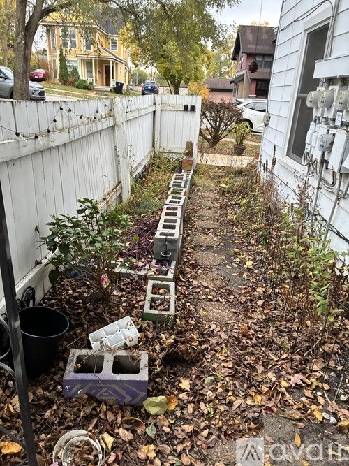 A garden with a white fence and a white house.