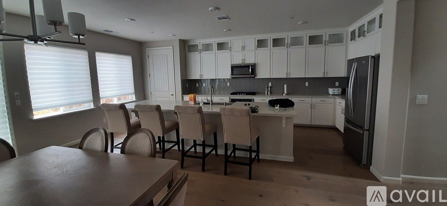 A kitchen with a table and chairs in front of it.